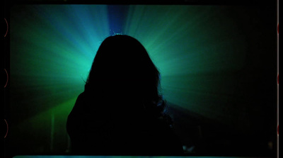 a woman standing in front of a green light