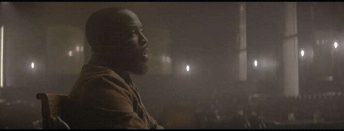 a man sitting in a chair in a dark room