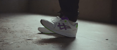 a person standing on a floor with a white and purple shoe