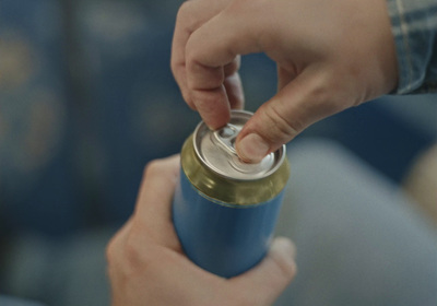 a person holding a can of soda in their hand