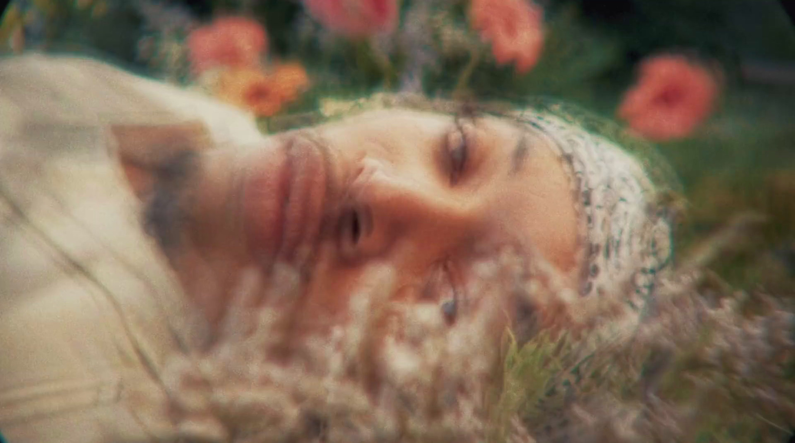 a woman laying down in a field of flowers