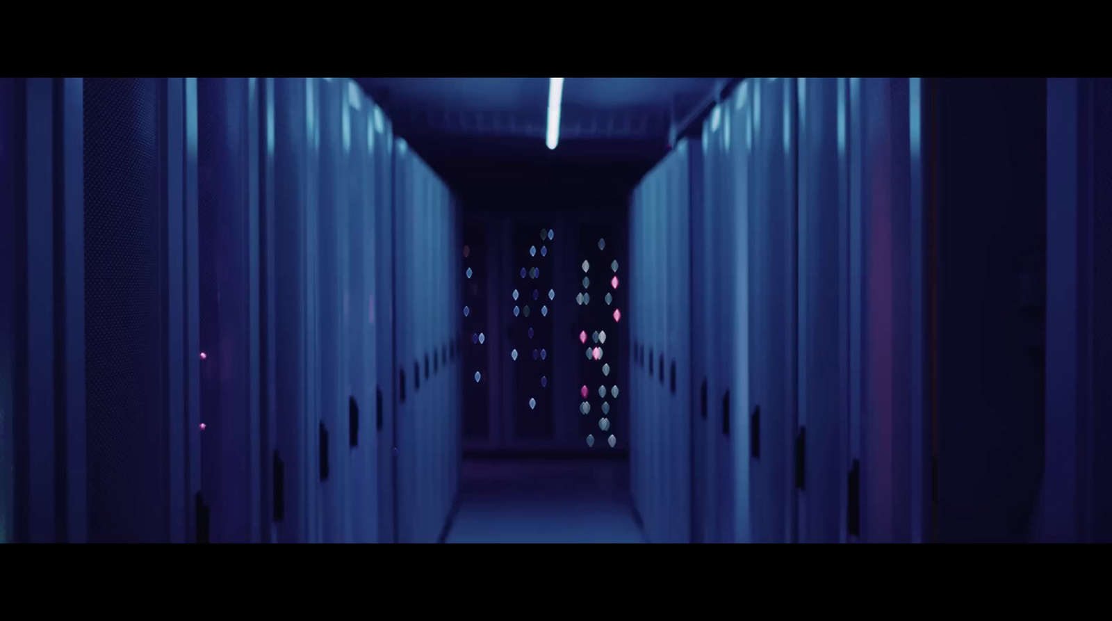 a long hallway with rows of servers in a data center