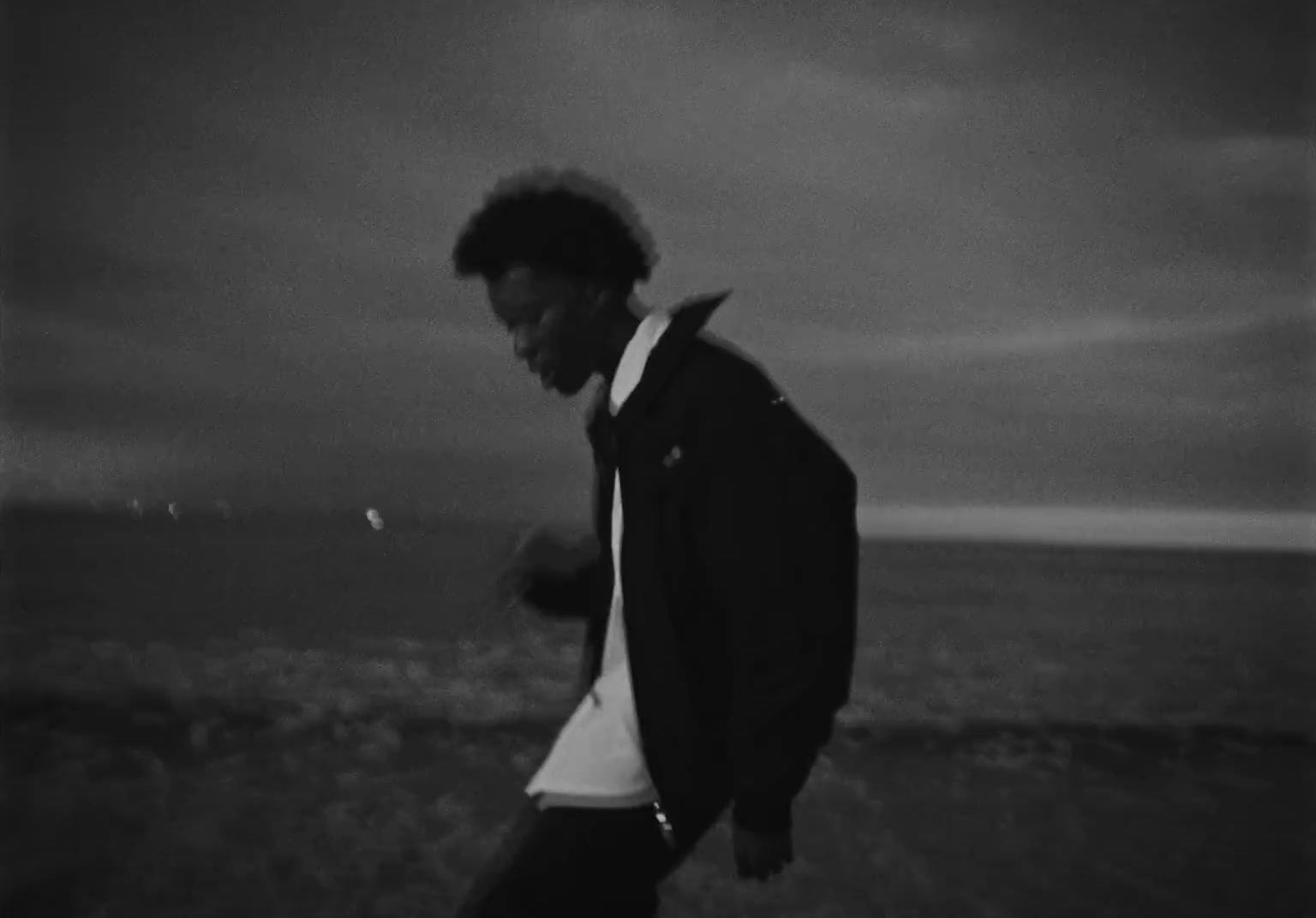 a man standing on top of a beach next to the ocean