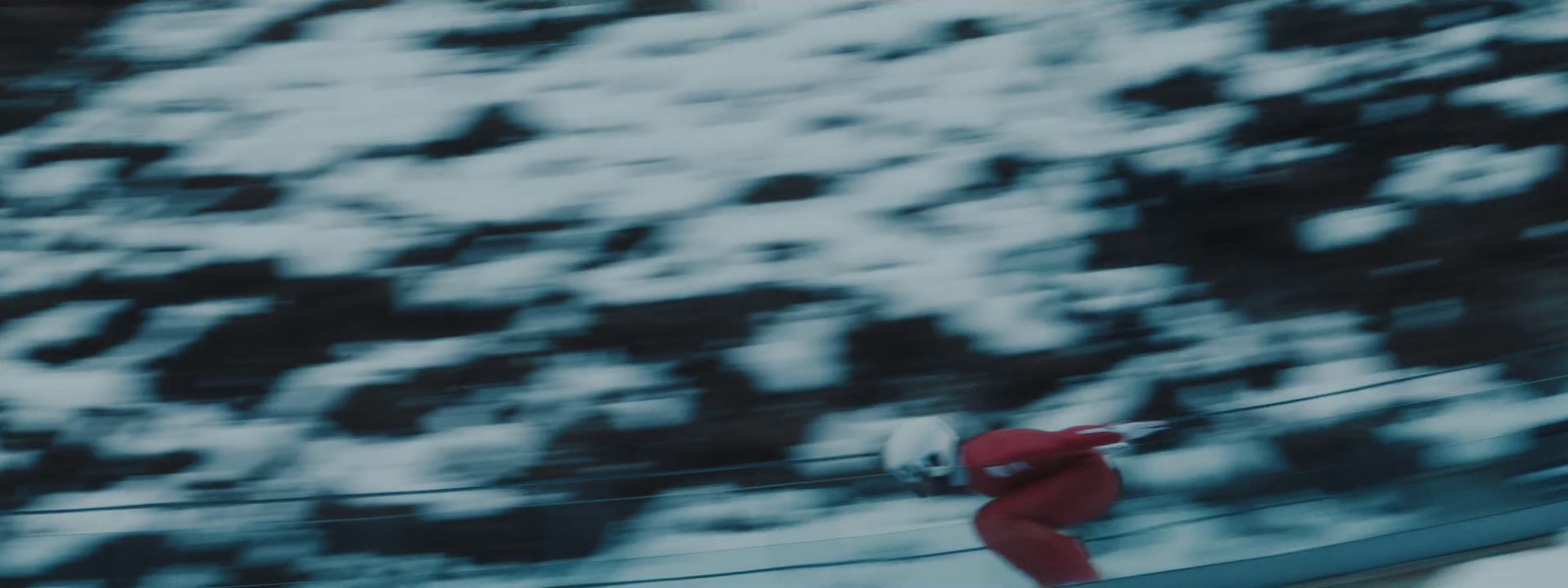 a man riding a snowboard down a snow covered slope