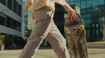 a man walking with a skateboard in his hand