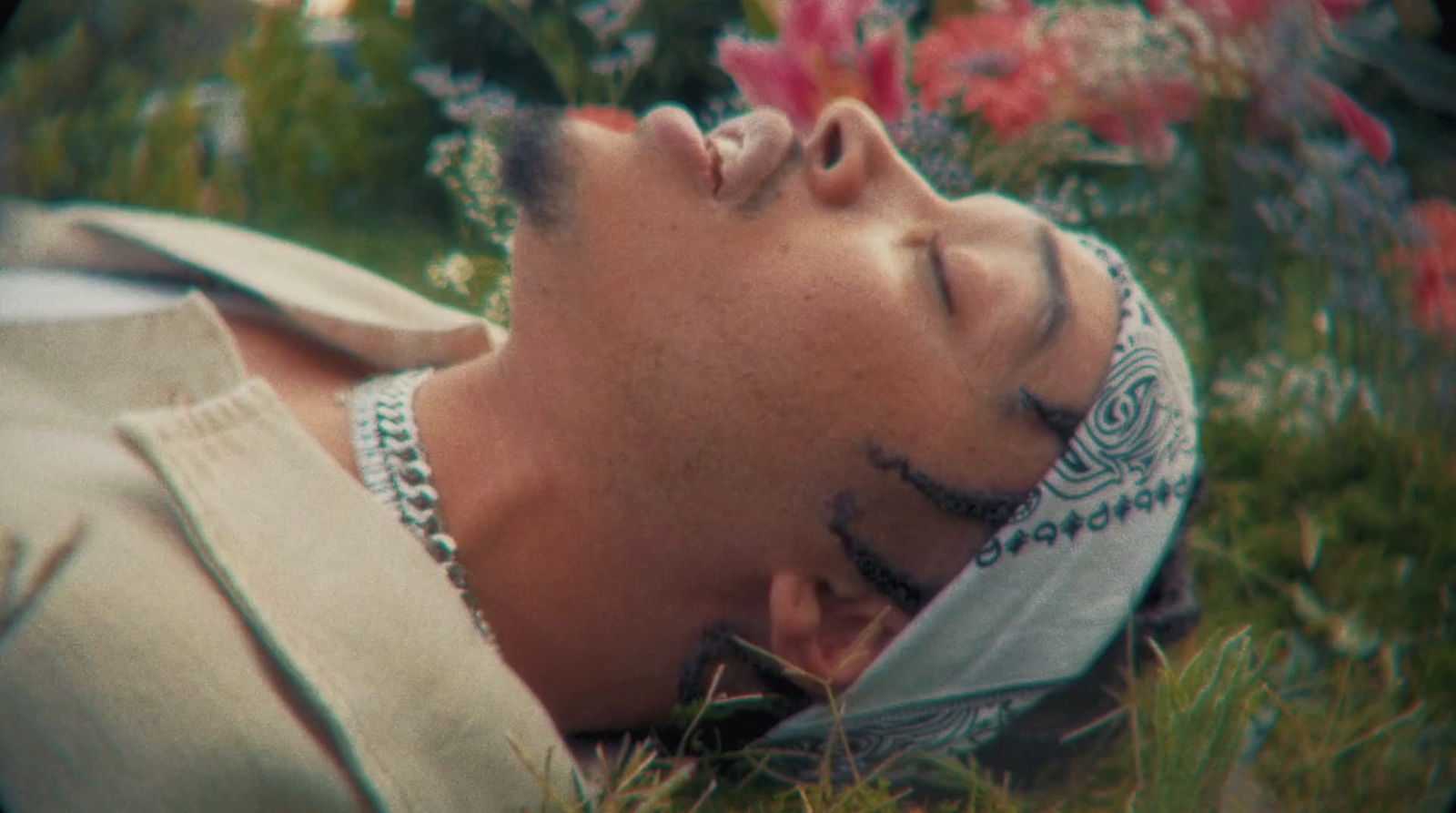 a man laying in the grass with his eyes closed