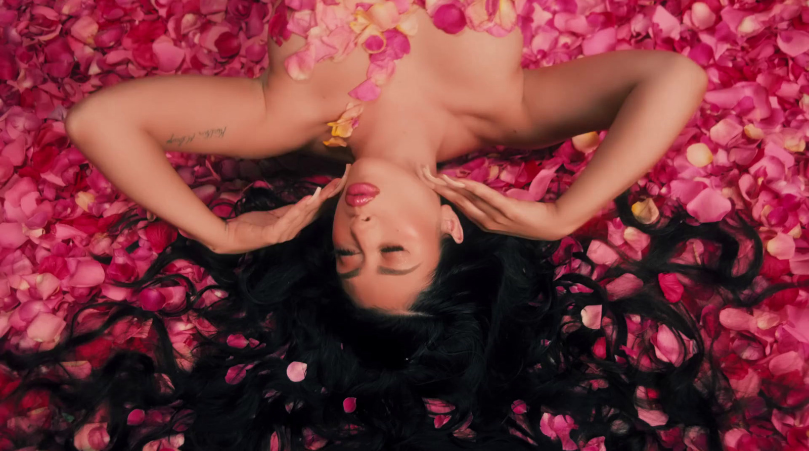 a woman laying on top of a bed of flowers