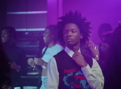 a man with dreadlocks standing in front of a group of people