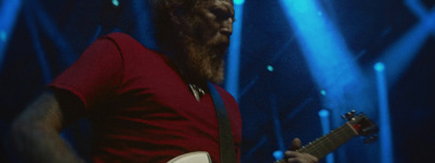 a man with a beard playing a guitar