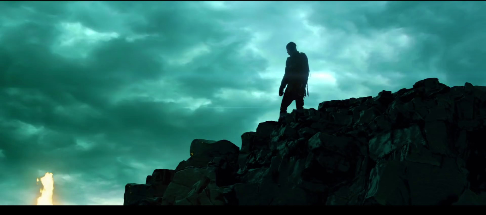 a man standing on top of a rocky cliff