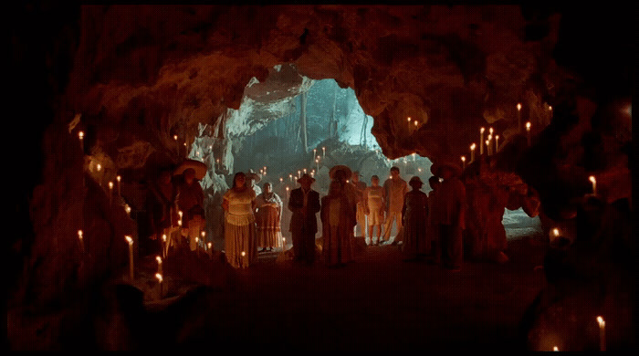 a group of people standing inside of a cave