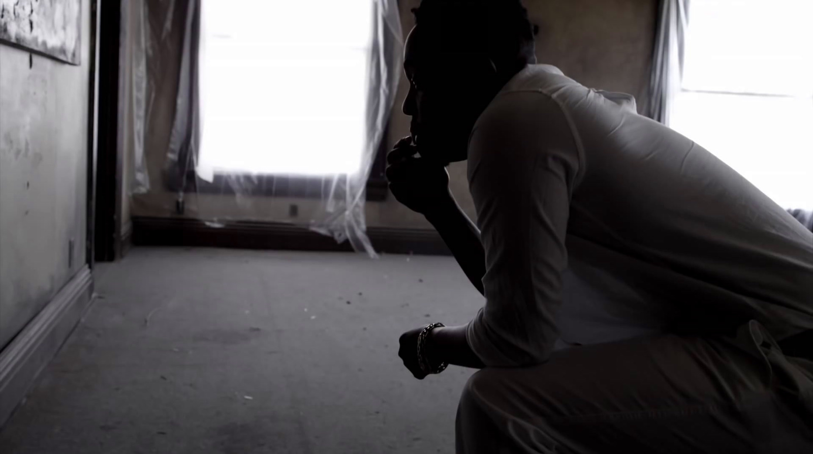 a person kneeling down in a room with a window