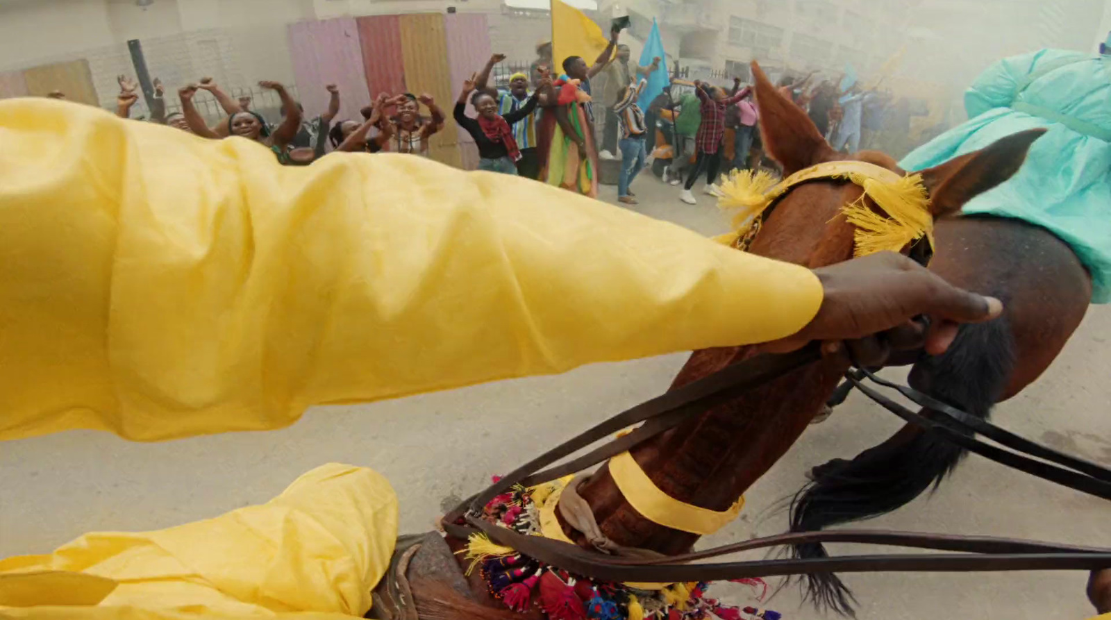 a person in a yellow outfit riding a horse