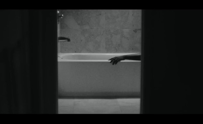 a black and white photo of a person's hand in a bathtub