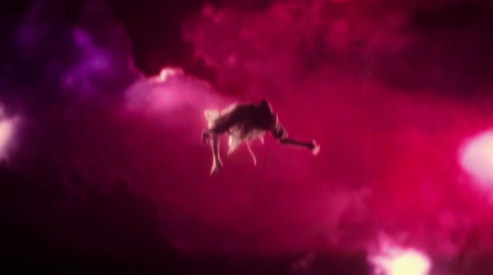 a cat flying through the air in a cloud filled sky