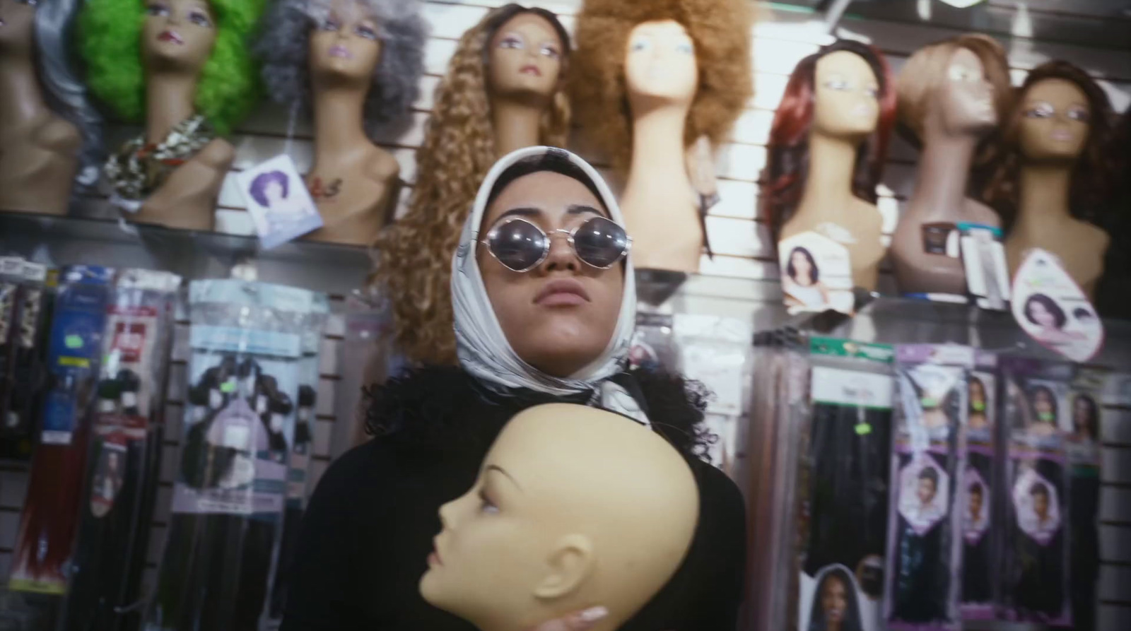 a woman holding a mannequin in front of a wall of mannequin