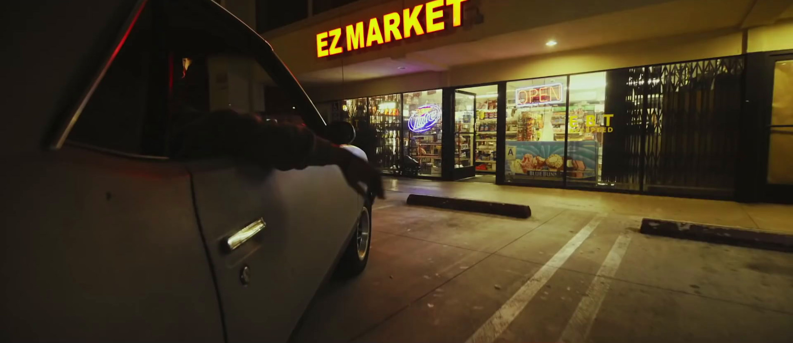 a car parked in front of a market at night