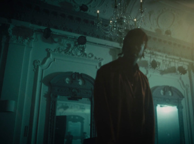 a man standing in a room with a chandelier