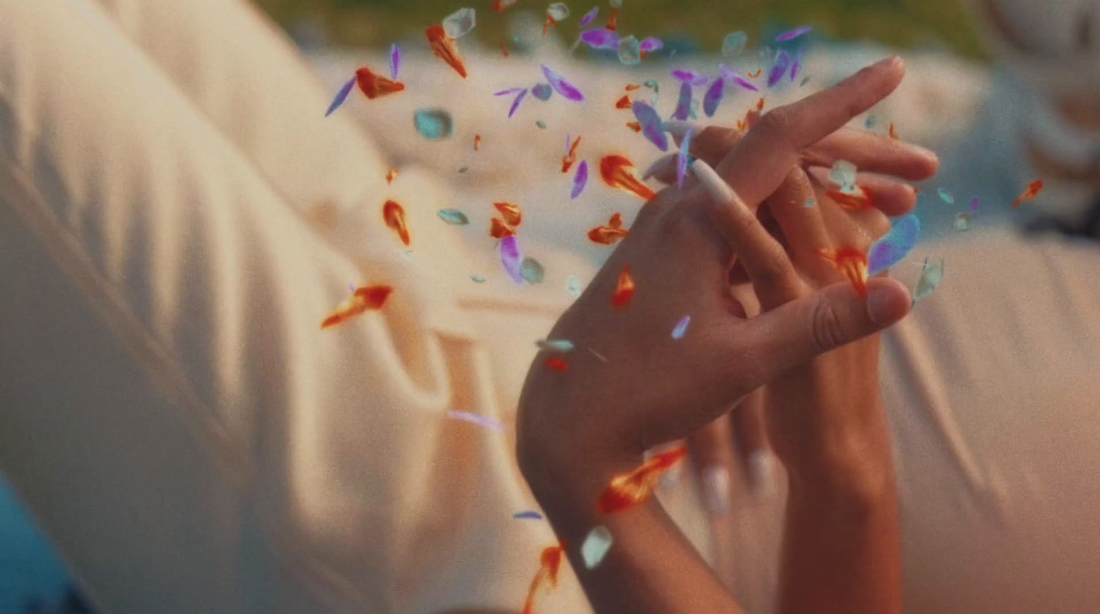 a woman laying on a bed with confetti falling from her hands