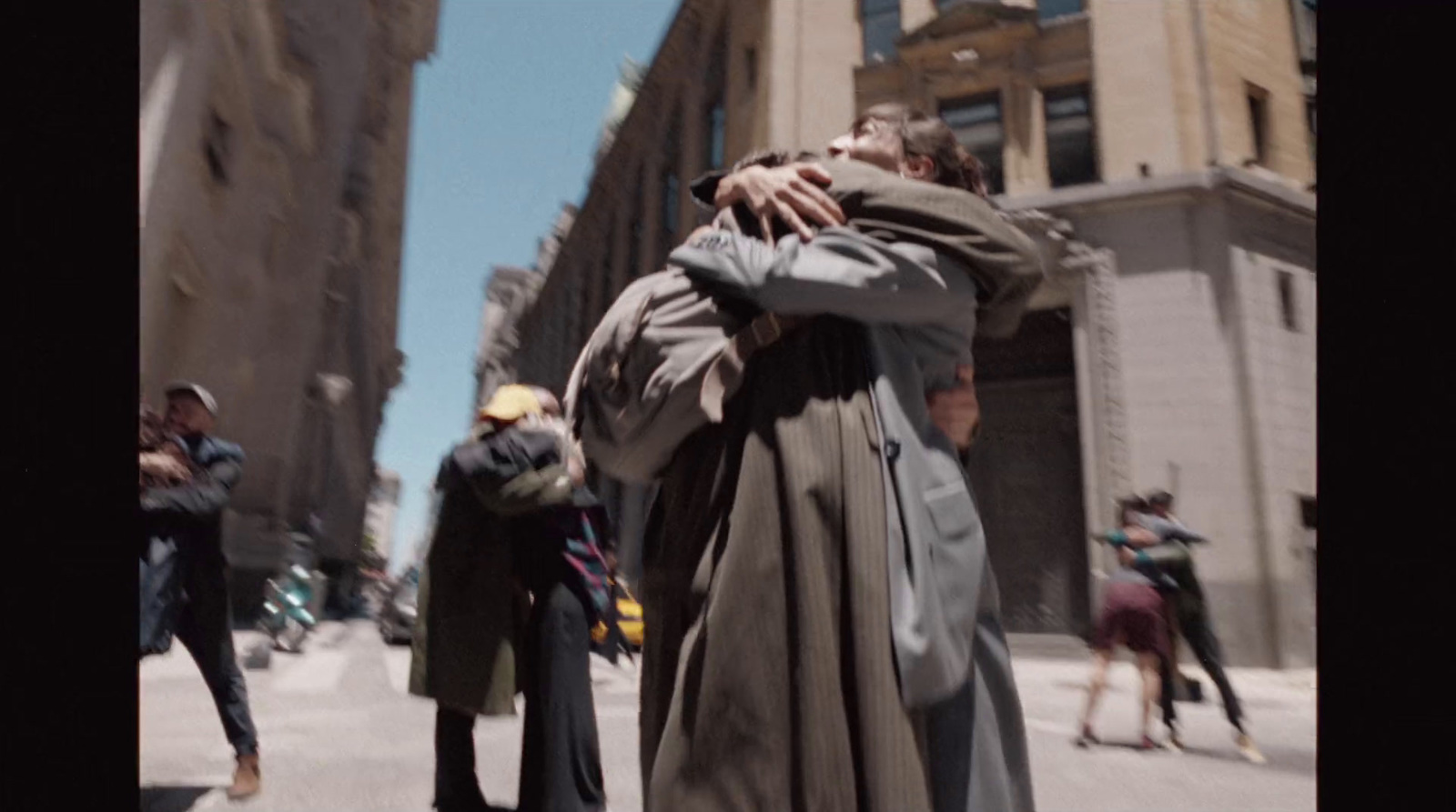 a man in a trench coat walking down a street