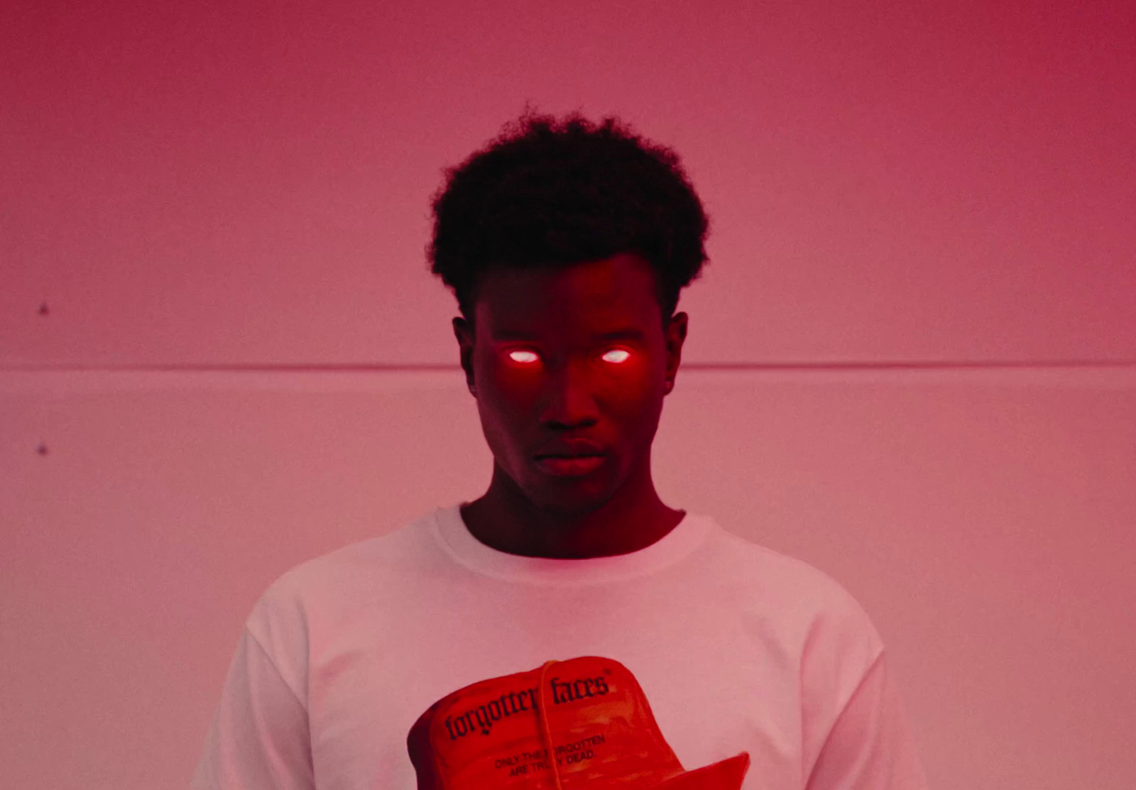 a man in a white shirt with a red light on his face