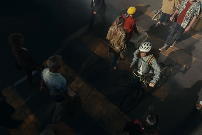 a group of people walking down a street next to a cross walk