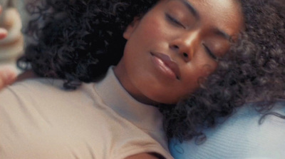 a woman sleeping on a couch with her eyes closed