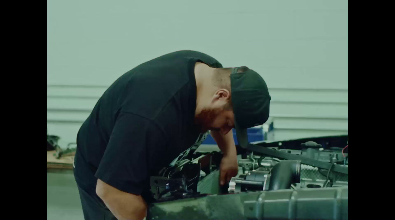 a man working on a car engine in a garage