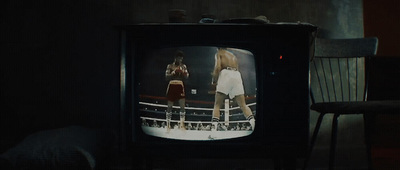 an old television with a female boxer on the screen