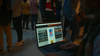 a group of people standing around a laptop computer