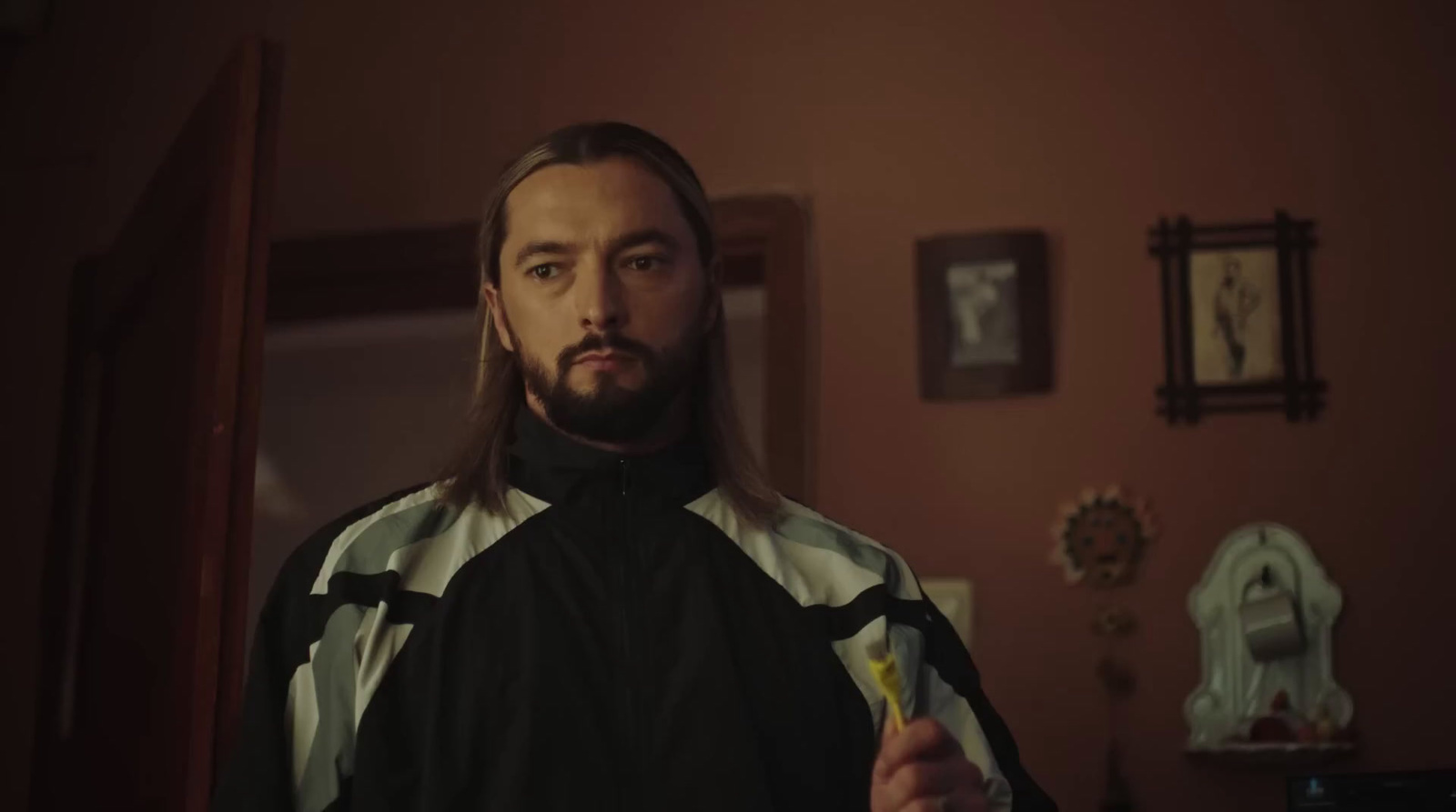 a man with long hair and a beard is holding a yellow toothbrush