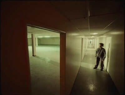 a man standing in a hallway in an empty building