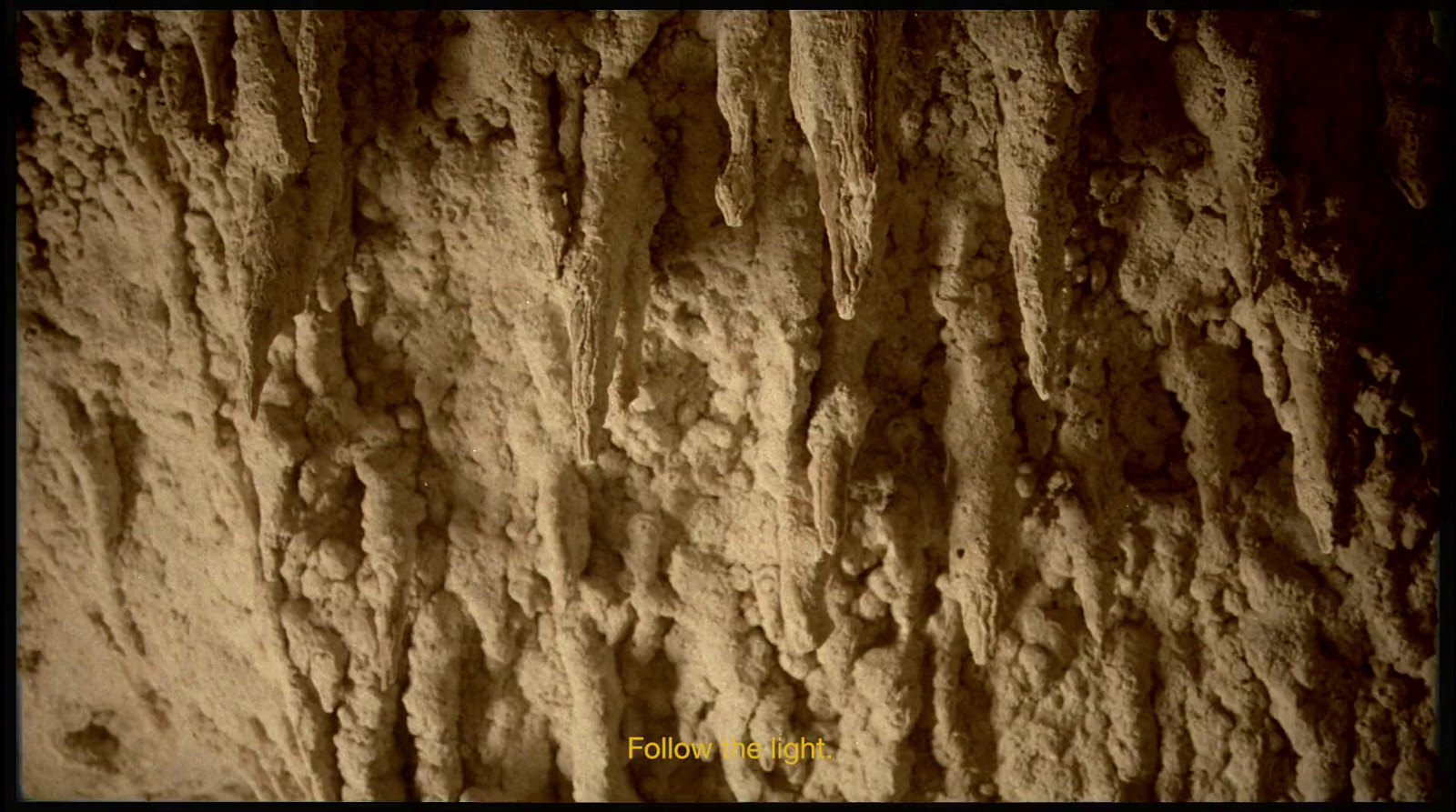 a close up of a rock face with cracks in it