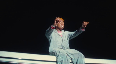 a woman sitting on a ledge with her hands in the air