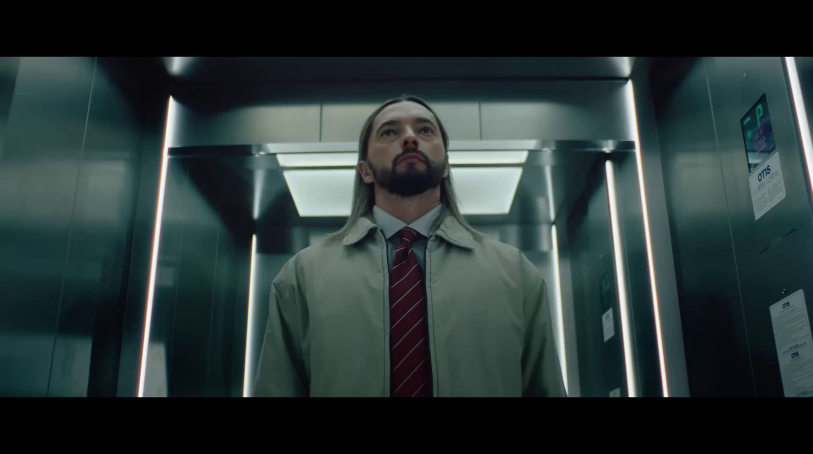 a man in a suit and tie standing in a elevator