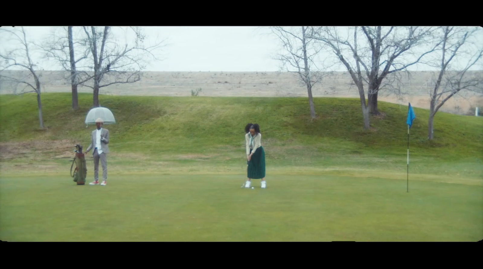 a couple of people standing on top of a green field