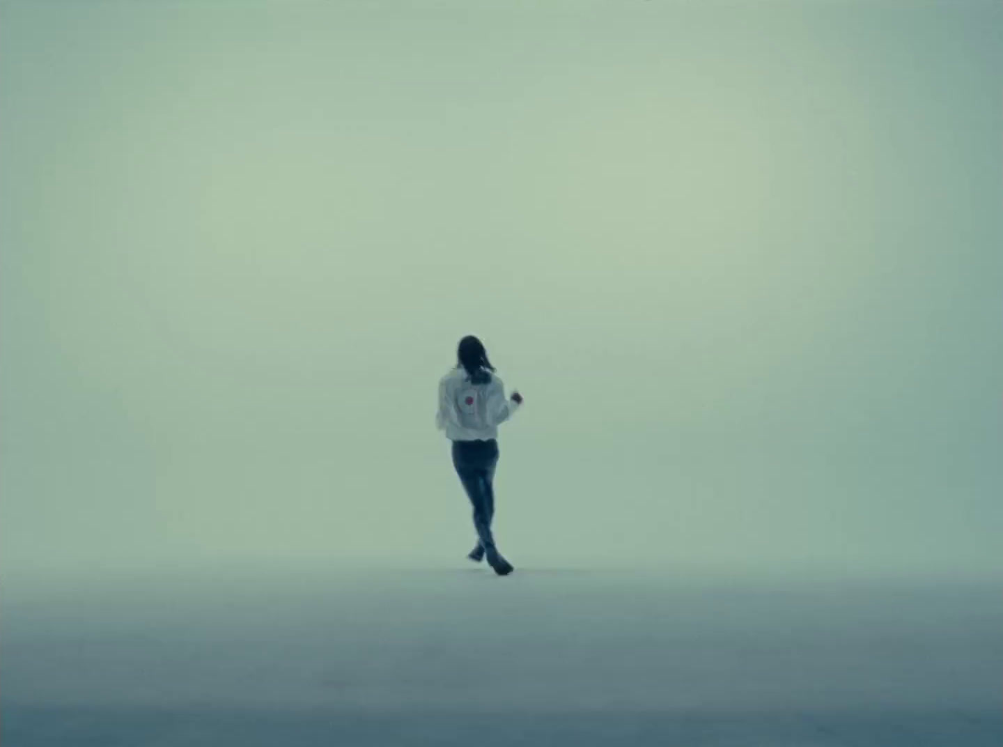 a woman in a white shirt is running in the fog