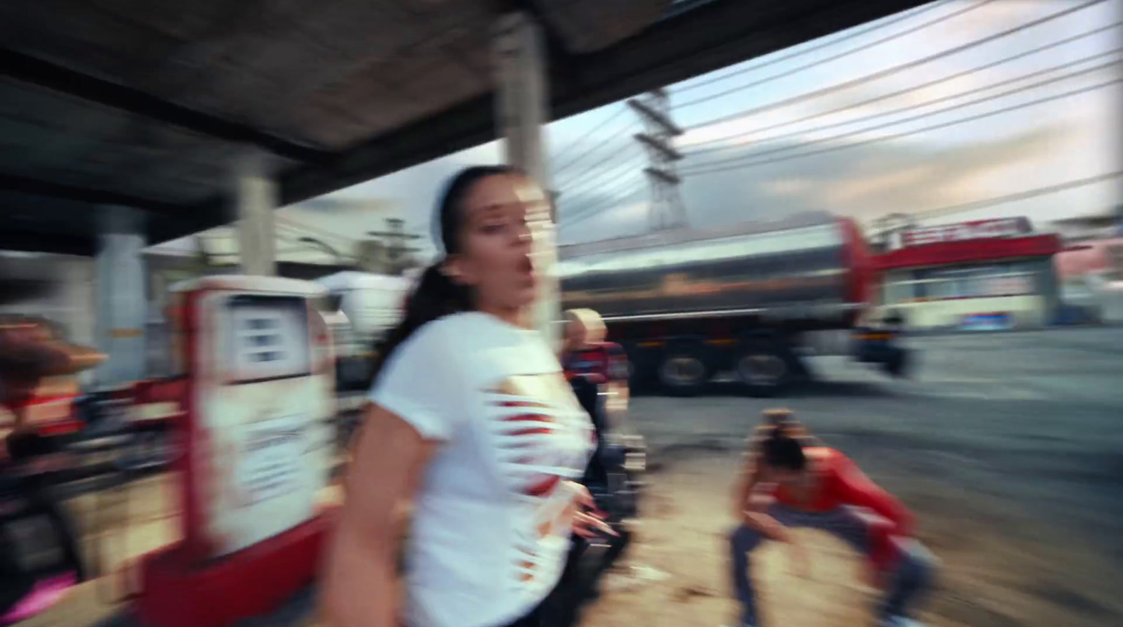 a blurry photo of a woman standing in front of a gas station