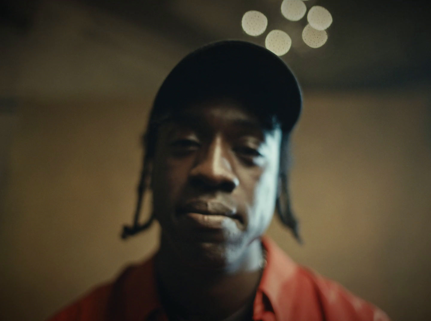 a man in a red shirt and a black hat