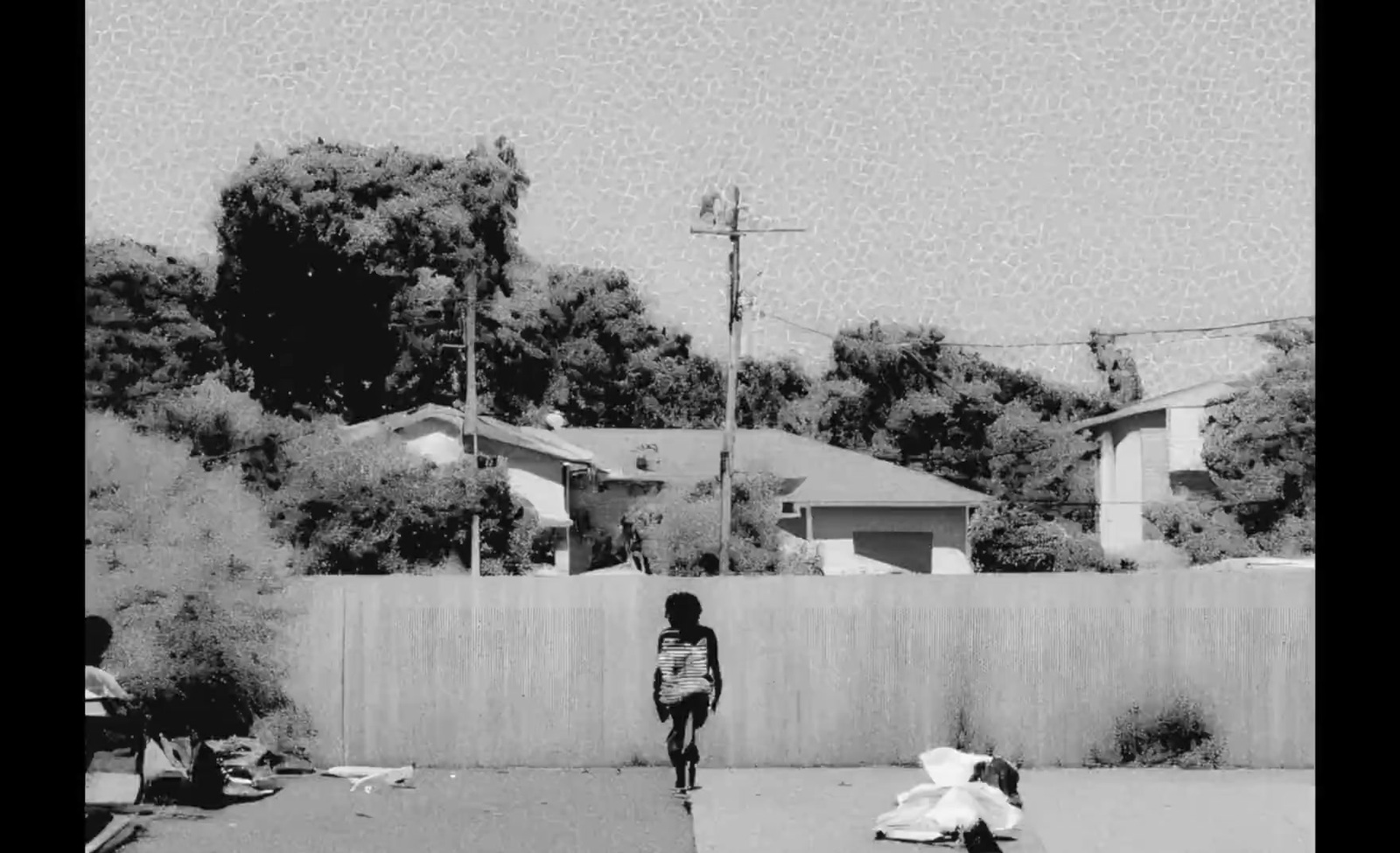 a black and white photo of a person walking down a street