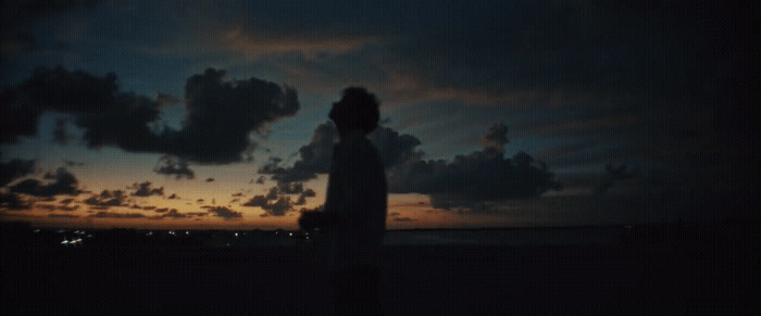 a person standing on a beach at night