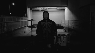 a person in a skeleton costume playing drums