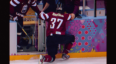 a couple of men standing on top of a ice rink