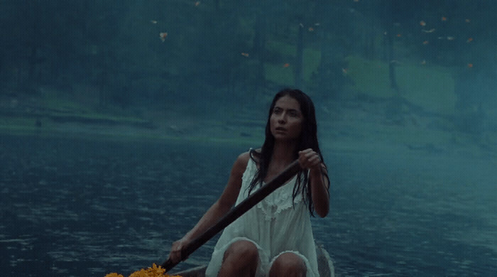 a woman in a white dress rowing a boat