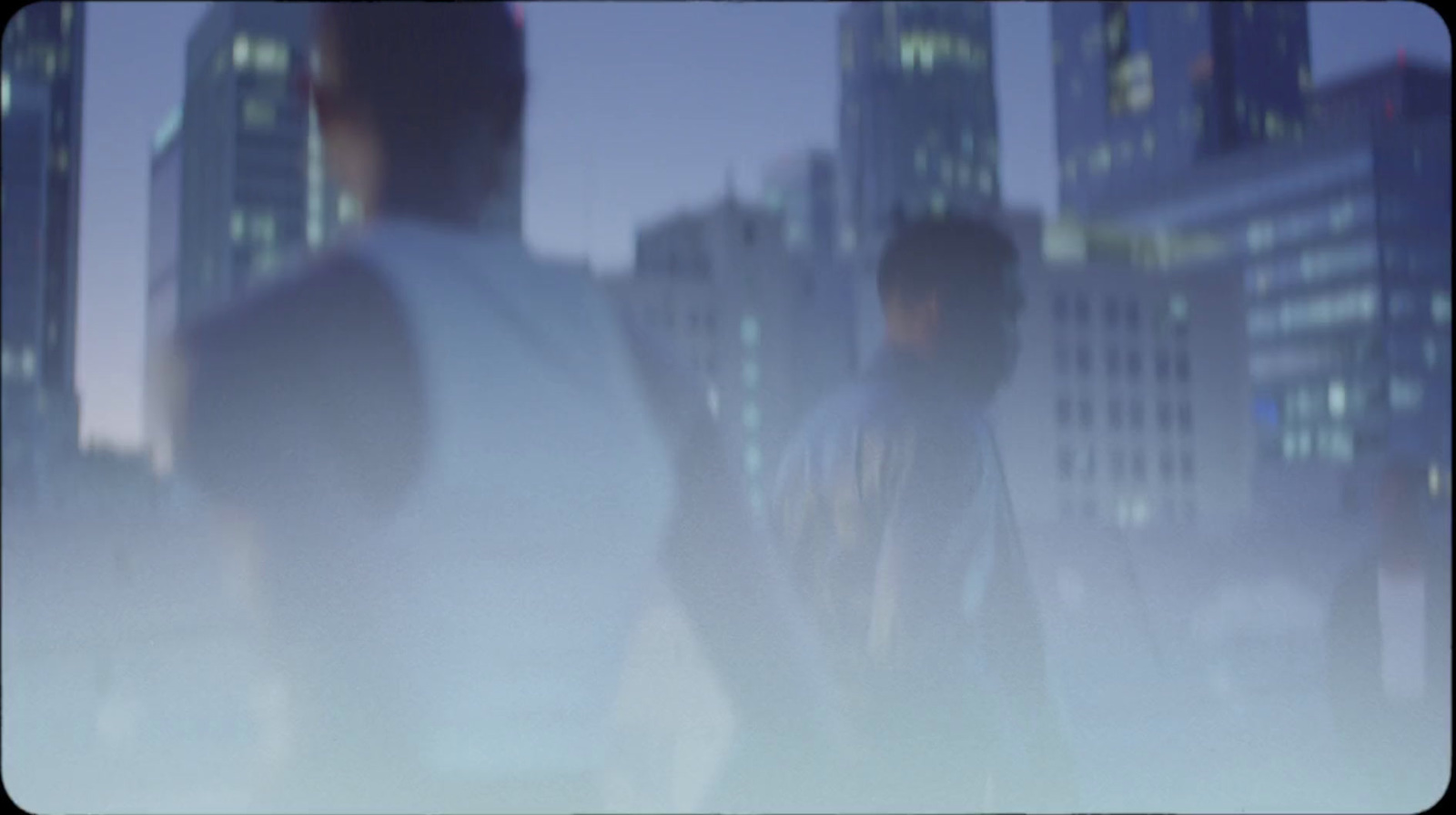 a blurry photo of two men standing in front of a cityscape