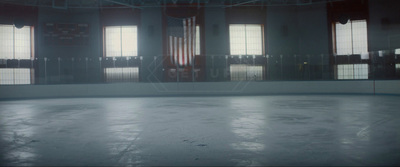 an empty ice rink with an american flag in the background