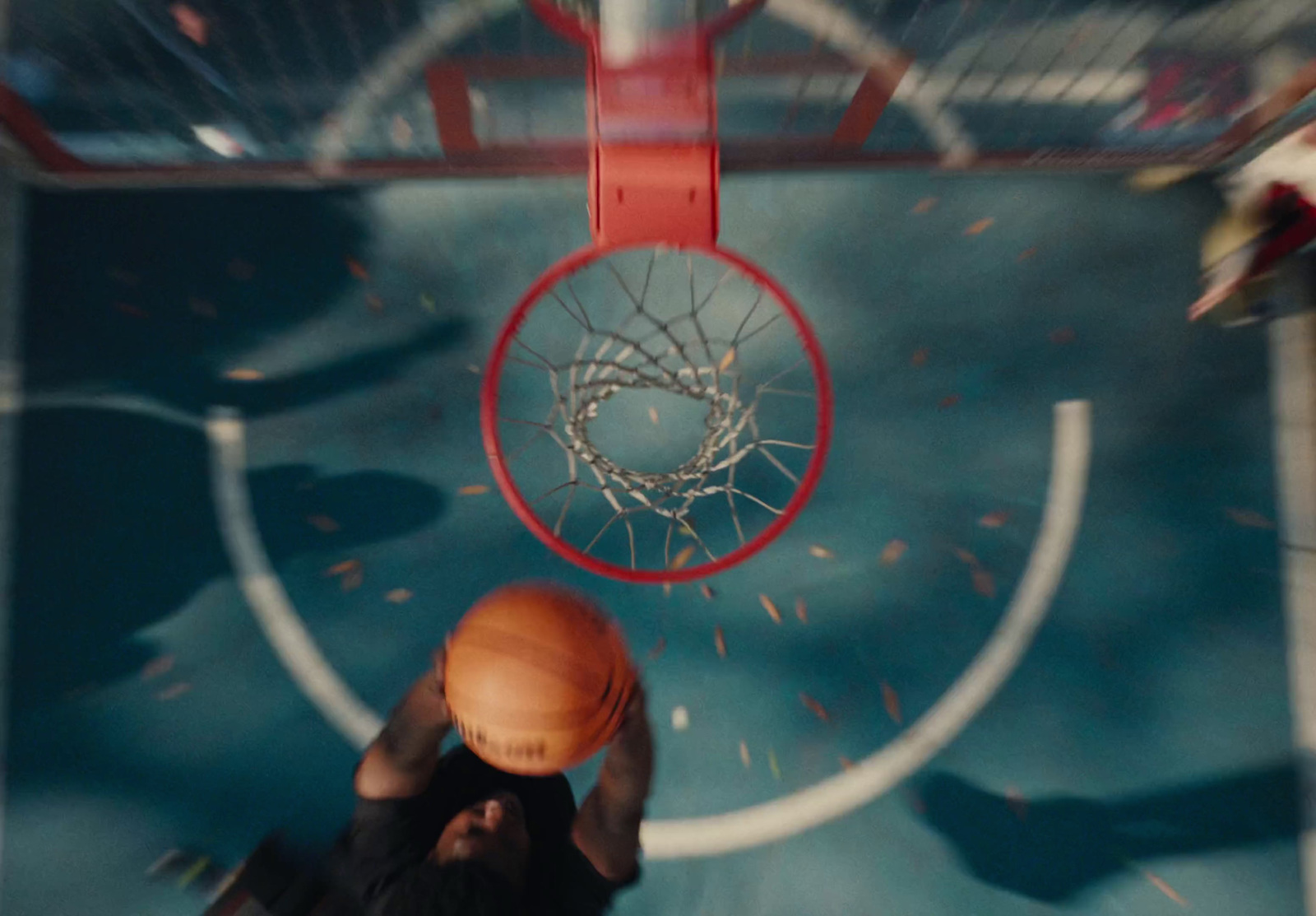 a basketball going through the net of a basketball court