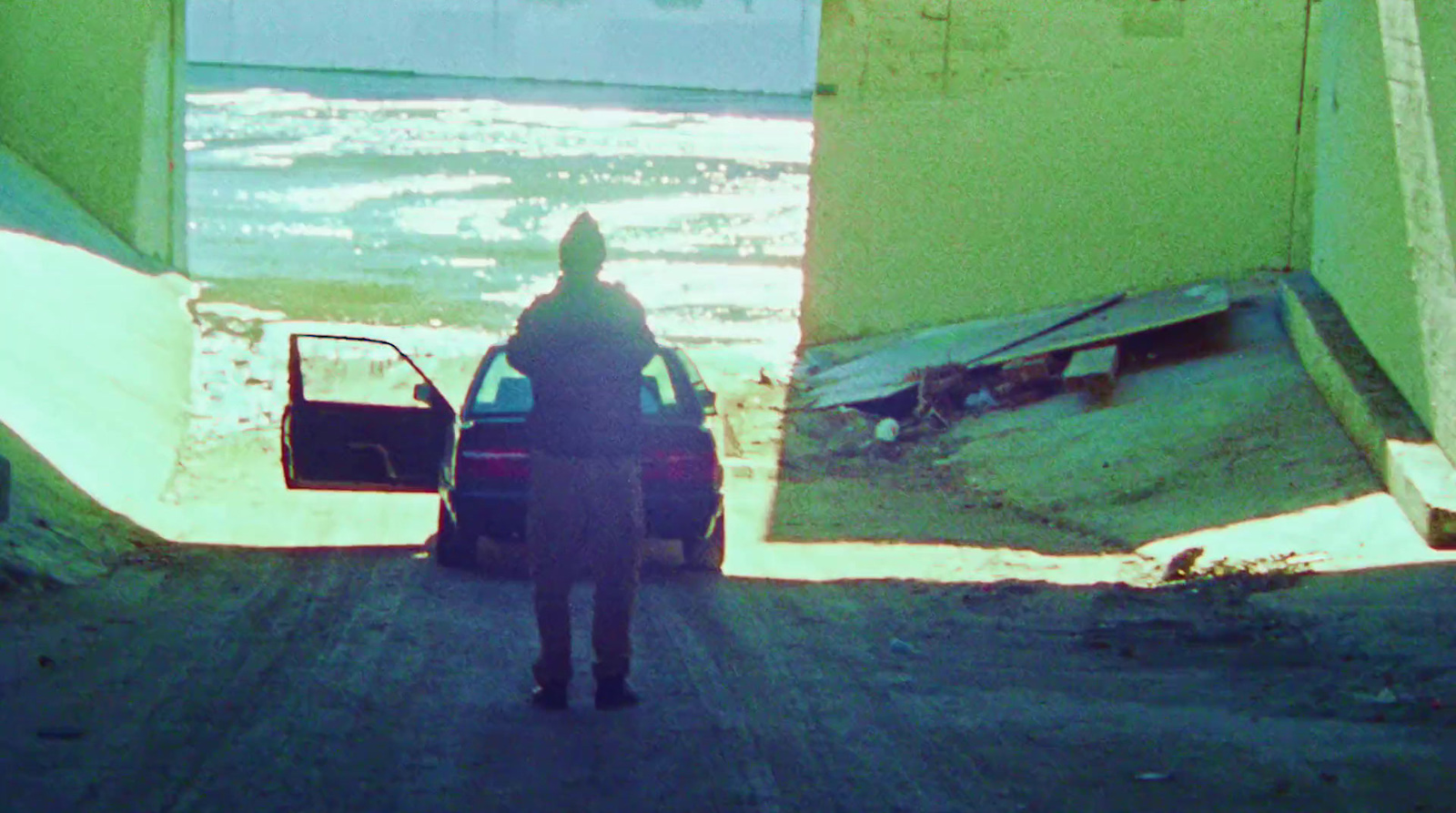 a person standing next to a car on a dirt road