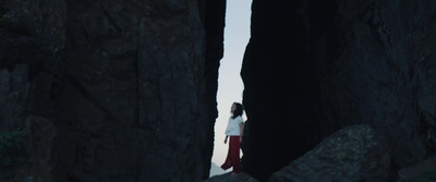 a woman standing in between two large rocks