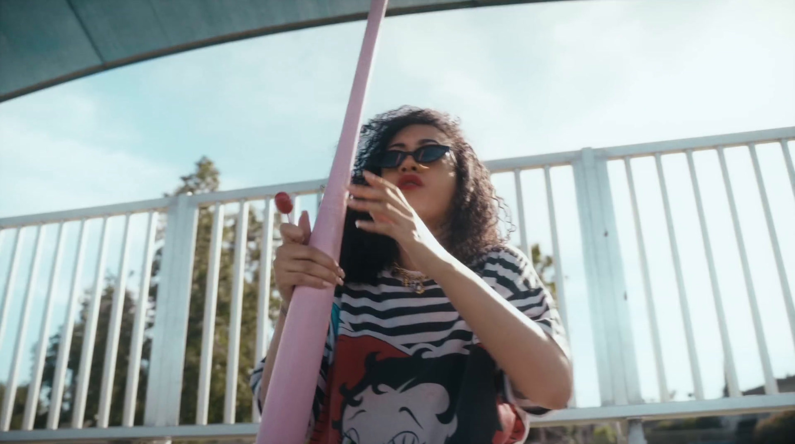 a woman holding a pink pole in front of her face